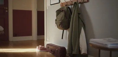 Flur mit Schulrucksack, Geigenkasten und Kinderschuhen im Nachmittagslicht