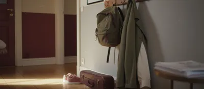 Flur mit Schulrucksack, Geigenkasten und Kinderschuhen im Nachmittagslicht